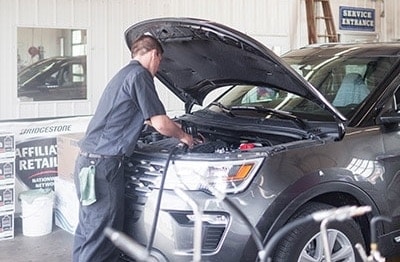 Oil change in Waupaca, WI | Little Wolf Automotive. Image of an auto mechanic doing service and maintenance on a car in an auto shop.