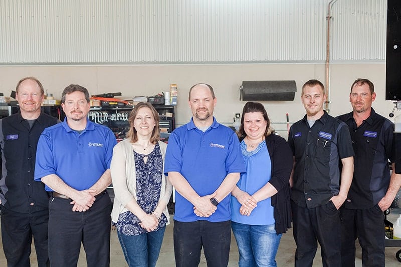 Picture of the Little Wolf Automotive team standing in the auto repair shop; meet the team