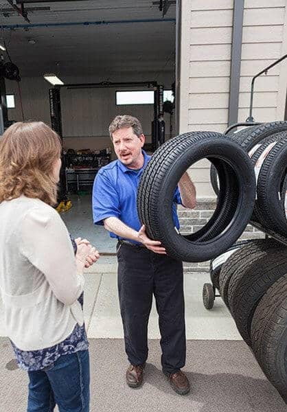 How Do You Know If You Need New Tires? | Little Wolf Automotive in Plover, WI. Image of a tires salesman helping a female customer choose new tires.