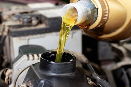 Does an Oil Change Improve Performance? | Little Wolf Automotive in Plover, WI. Closeup image of a fresh motor oil poured into a car engine.