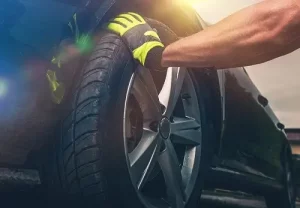 How Tire Rotation is Done | Little Wolf Automotive in Plover, WI. Image of mechanic preparing to remove the front tire and place it in another wheel position.
