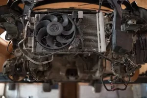 Parts of a car’s cooling system | Little Wolf Automotive in Waupaca, WI. Image of a disassembled machine front, car radiator and fan.
