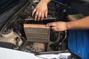 An auto mechanic showing an old engine air filter. Concept image of “6 Signs of a Bad Engine Air Filter” | Little Wolf Auto in Plover, WI.