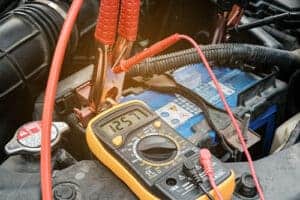Closeup view of an electric multimeter voltmeter to check the voltage level of a car battery. Concept image of “When Should I Replace My Car Battery?” | Little Wolf Auto in Antigo, WI.