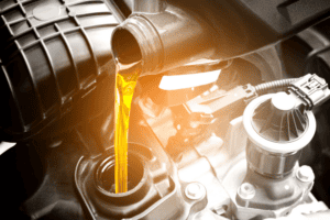 Oil change service in Antigo, WI at Little Wolf Express Lube. Image of a mechanic pouring high-quality motor oil into a car engine during an oil change service.
