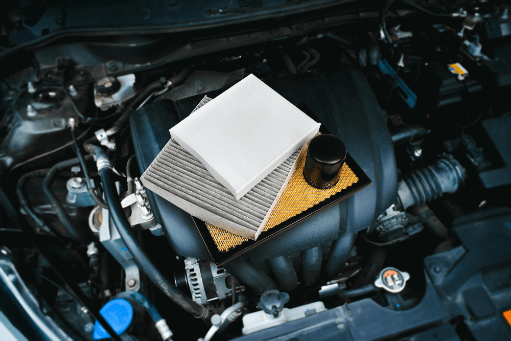 engine air filter replacement, auto repair in Little Wolf Automotive at Waupaca, WI. Various car filters, including cabin, air, and oil filters, displayed on an engine.