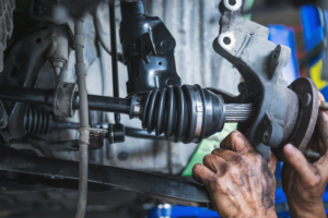 axle replacement, auto repair in Little Wolf Automotive at Antigo, WI. Mechanic installing a new CV axle in a vehicle’s suspension system, ensuring proper drivetrain function and smooth handling.