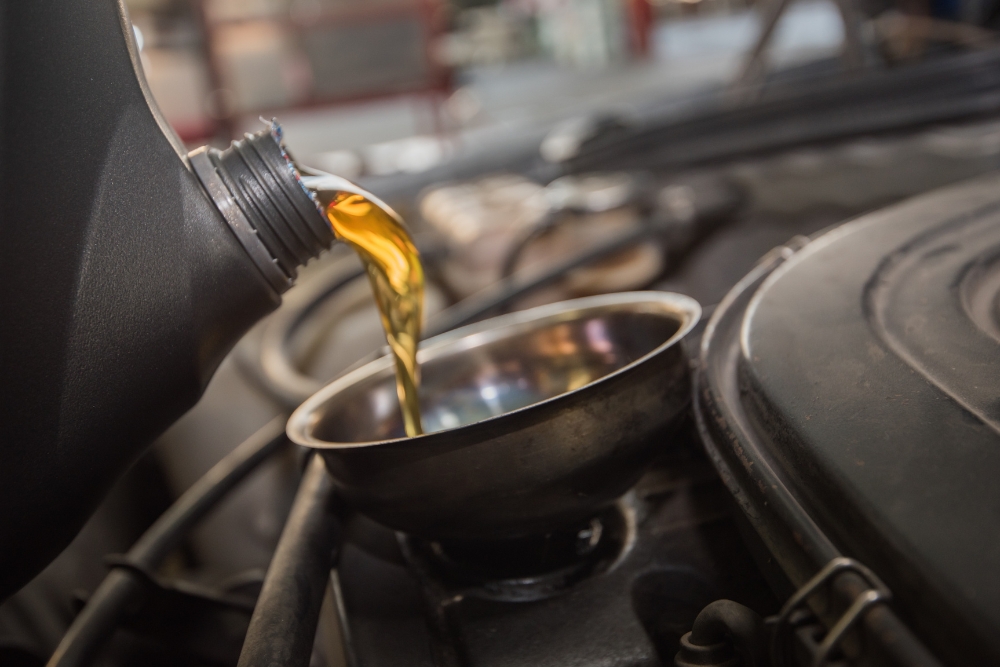 a pouring oil into a car Express Lube, Oil Change In Rothschild WI At Eagle Express Lube