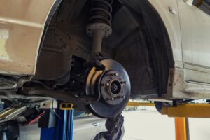 Suspension & Brake Repair In Waupaca WI At Little Wolf. Car lifted in auto repair shop for brake repair and suspension inspection.