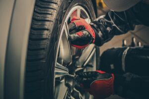 Tire Service, Fall Car Care Tips in Rothschild, WI At Eagle Express Lube. Close-up view of a mechanic working on a vehicle tire during a tire service at an auto repair shop.