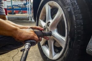 Winter Tire Service in Waupaca WI At Little Wolf Automotive. Mechanic working on vehicle tire at auto repair shop,