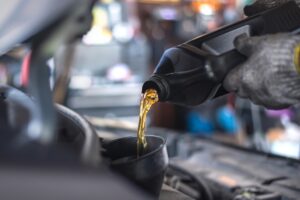 Cold-Weather Oil Change in Antigo WI At Little Wolf Automotive. Mechanic performing a winter oil change on a car engine