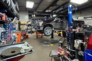 Auto Repair in Wausau WI At Little Wolf Automotive. Vehicle raised on lift for inspection and maintenance inside auto repair shop