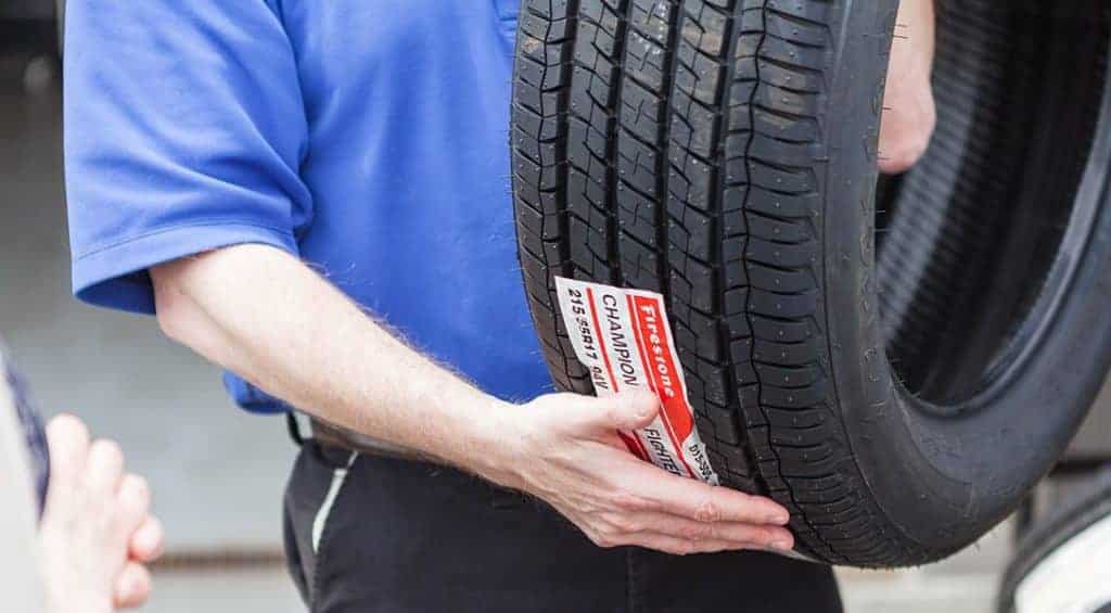 New tires and tire installation at Little Wolf Automotive, closeup image of owner Scott Bickley holding new tire