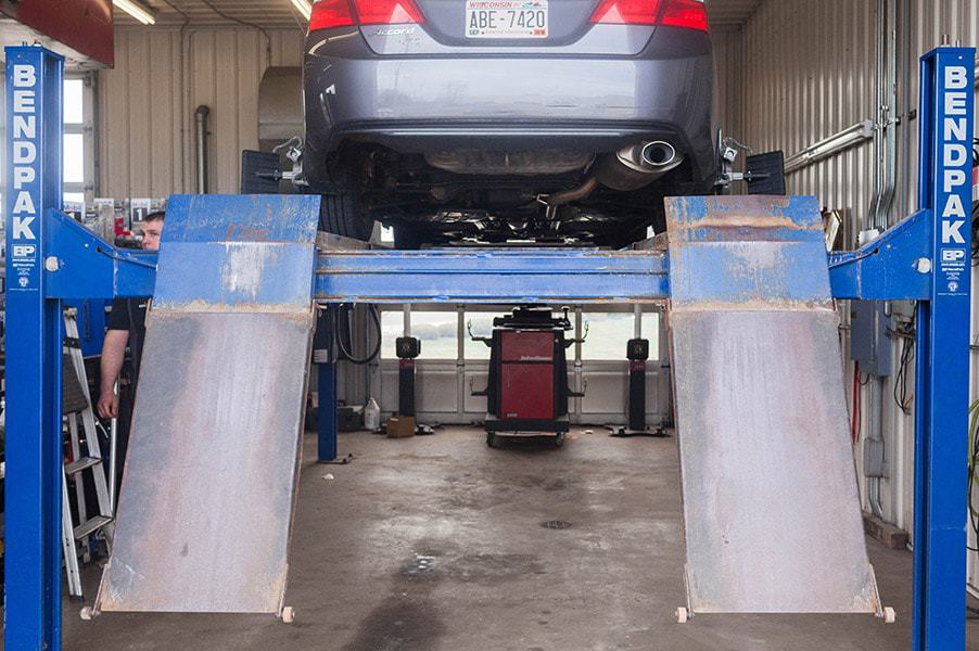 Wheel alignment | Little Wolf Automotive | Waupaca, WI, image of back of vehicle that is raised on alignment machine in shop
