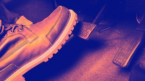 5 Signs You Need New Brakes | Little Wolf Automotive Express Lube in Waupaca, WI. Closeup image of a foot with shoe as well as the accelerator and brake pedals of a car.