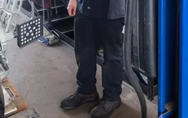 Wheel Alignment by Little Wolf Auto. Image of a mechanic and a car with alignment sensor.