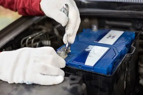 Is Your Car Battery Due for Replacement? | Little Wolf Automotive in Waupaca, WI. Image of a mechanic discharging the car battery and repairing the car.
