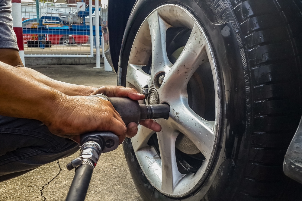 Winter Tire Service in Waupaca WI At Little Wolf Automotive. Mechanic working on vehicle tire at auto repair shop,